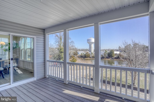 unfurnished sunroom with a wealth of natural light and a water view