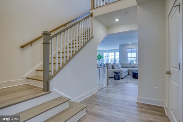 staircase with baseboards, recessed lighting, and wood finished floors