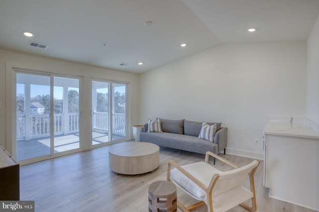 living room featuring light wood-type flooring, visible vents, recessed lighting, and baseboards