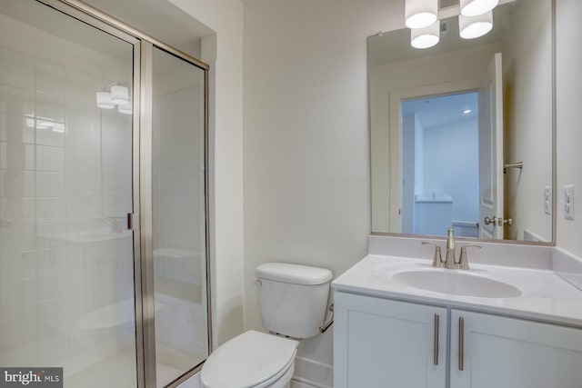 bathroom featuring a stall shower, vanity, and toilet