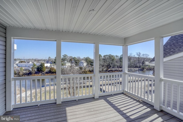 unfurnished sunroom featuring a water view