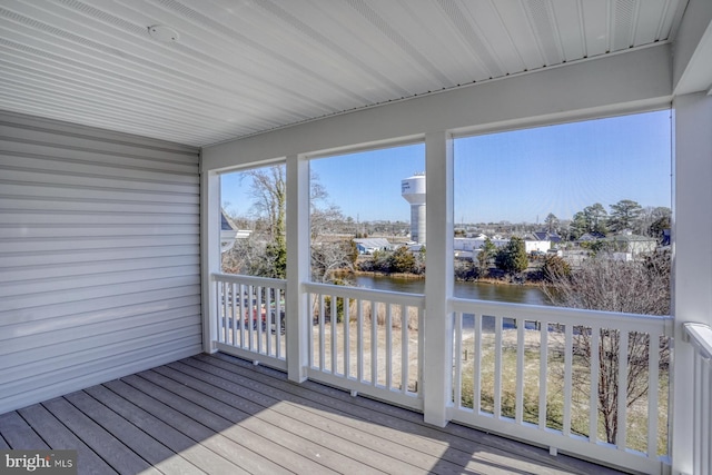 unfurnished sunroom featuring a water view and a healthy amount of sunlight