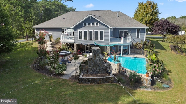 back of house featuring a deck, fence, a lawn, a fenced in pool, and a patio area