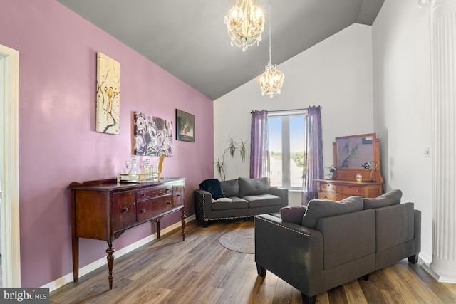 living room featuring lofted ceiling, hardwood / wood-style floors, and a notable chandelier