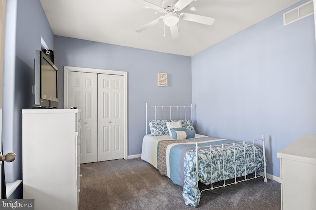 bedroom featuring dark carpet, ceiling fan, and a closet