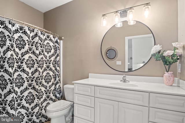 bathroom featuring toilet, curtained shower, and vanity