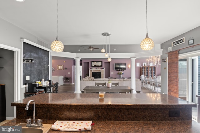 kitchen featuring sink, ornate columns, wood-type flooring, ceiling fan, and pendant lighting