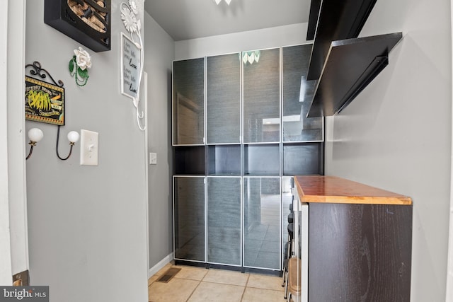 bathroom featuring tile patterned flooring, visible vents, and baseboards