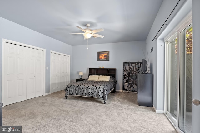 carpeted bedroom with multiple closets and ceiling fan