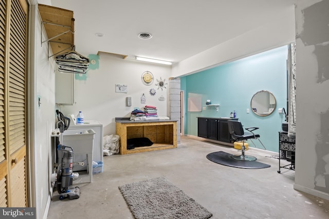 interior space with unfinished concrete flooring, a sink, visible vents, and baseboards