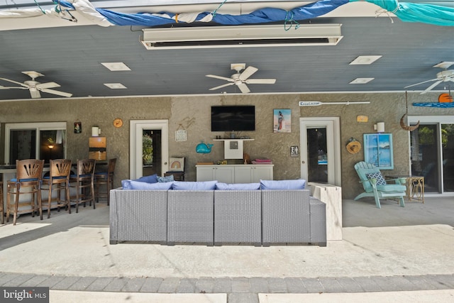 view of patio / terrace featuring exterior bar, an outdoor living space, and ceiling fan