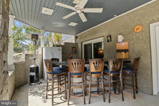 view of patio with a ceiling fan, outdoor wet bar, and fence