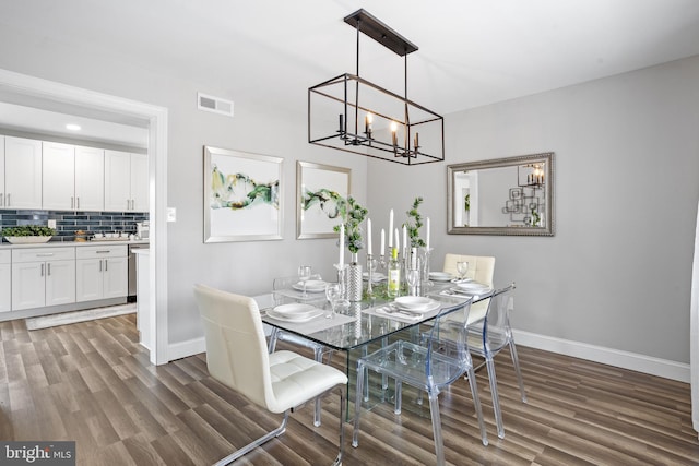 dining space with a notable chandelier and dark wood-type flooring