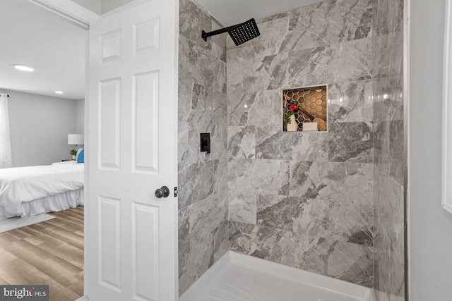 bathroom featuring hardwood / wood-style flooring and tiled shower