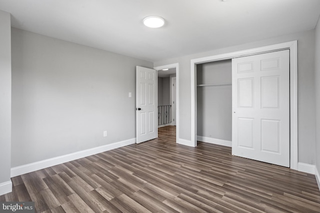 unfurnished bedroom featuring dark hardwood / wood-style floors and a closet