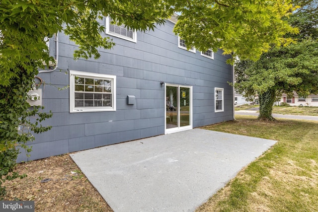 rear view of property featuring a patio area and a lawn