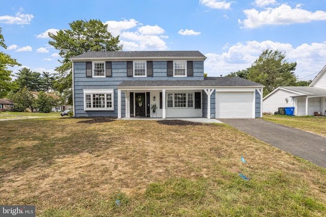 view of front facade featuring a garage, a front yard, and a porch