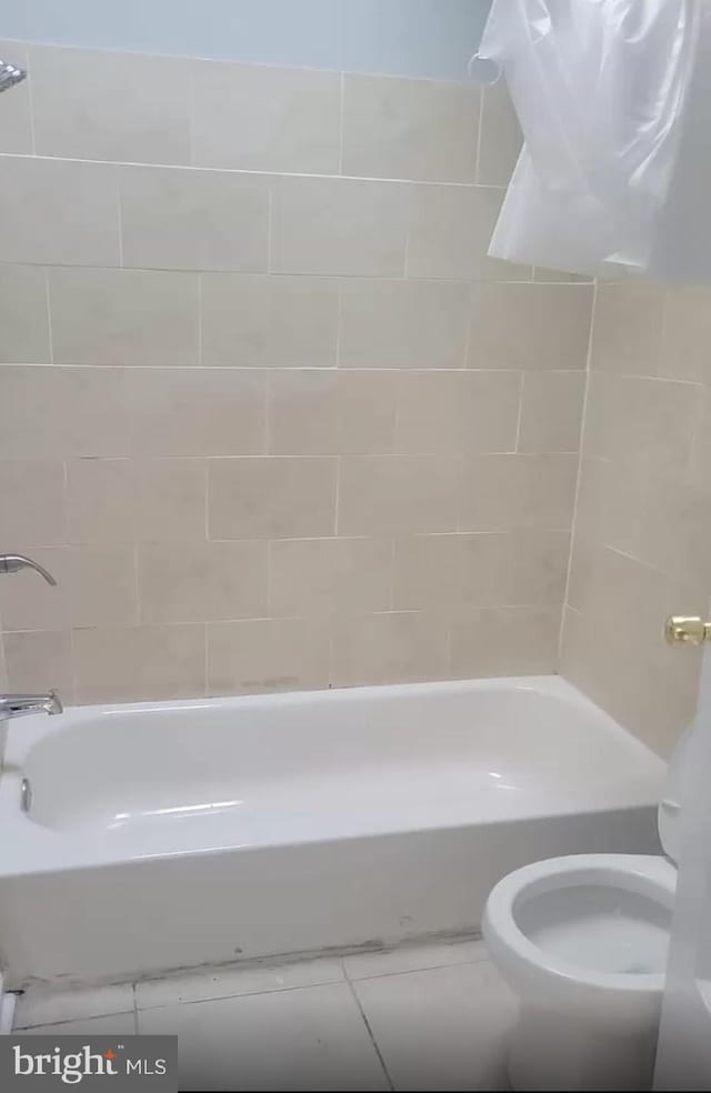 bathroom with tile patterned flooring, tub / shower combination, and toilet