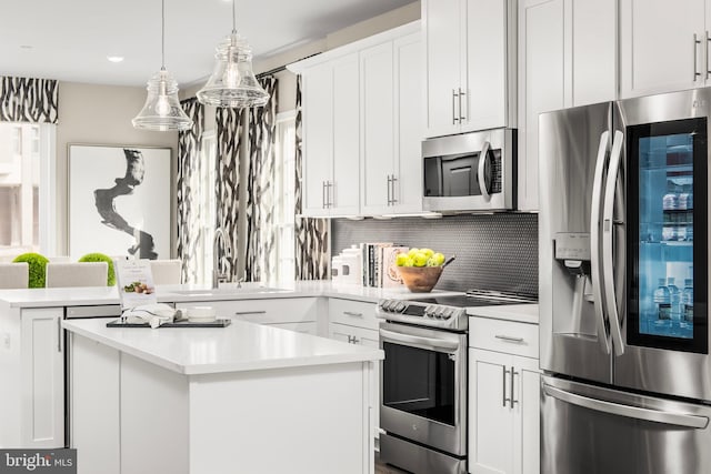 kitchen with decorative backsplash, white cabinetry, pendant lighting, stainless steel appliances, and sink