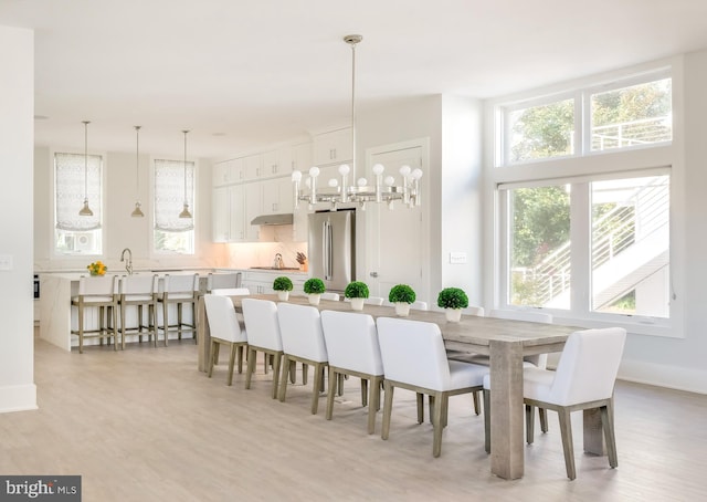 dining room with light hardwood / wood-style floors, sink, and a wealth of natural light