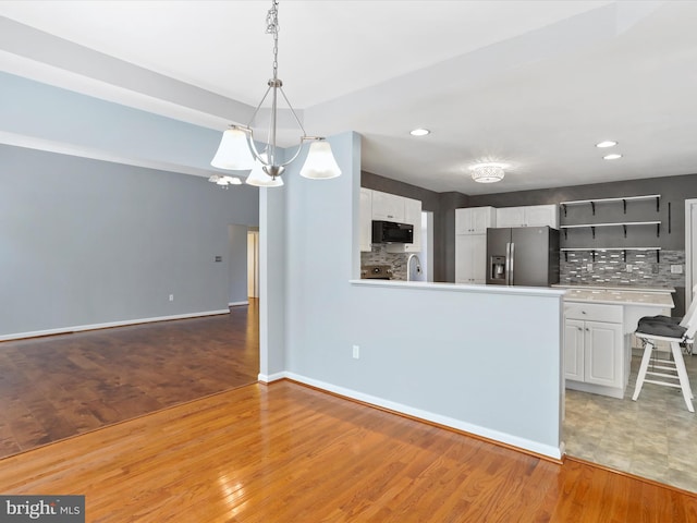 kitchen featuring white cabinets, stainless steel refrigerator with ice dispenser, and light wood-type flooring