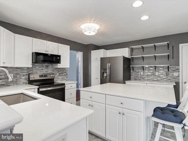 kitchen featuring tasteful backsplash, white cabinetry, appliances with stainless steel finishes, and sink