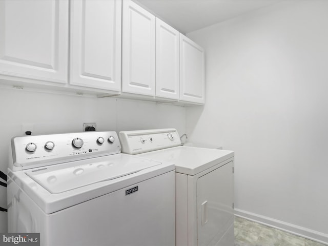 washroom featuring washer and clothes dryer and cabinets