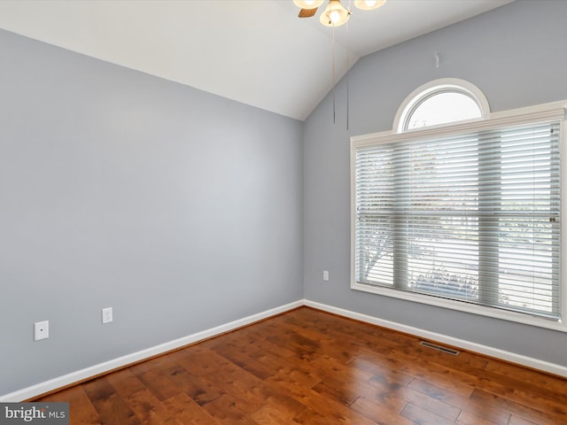 empty room with hardwood / wood-style flooring, a healthy amount of sunlight, and vaulted ceiling