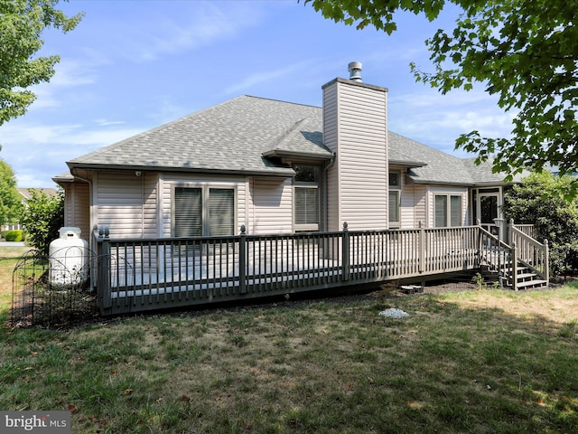 back of house with a deck and a lawn