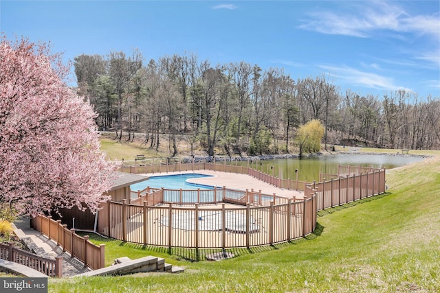 view of swimming pool with a water view and a lawn