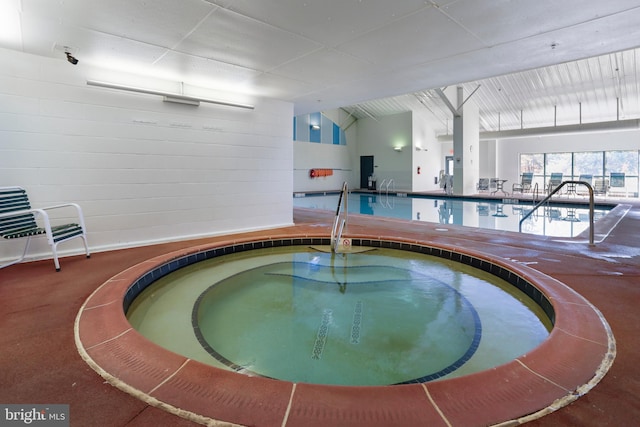 view of swimming pool with an indoor hot tub