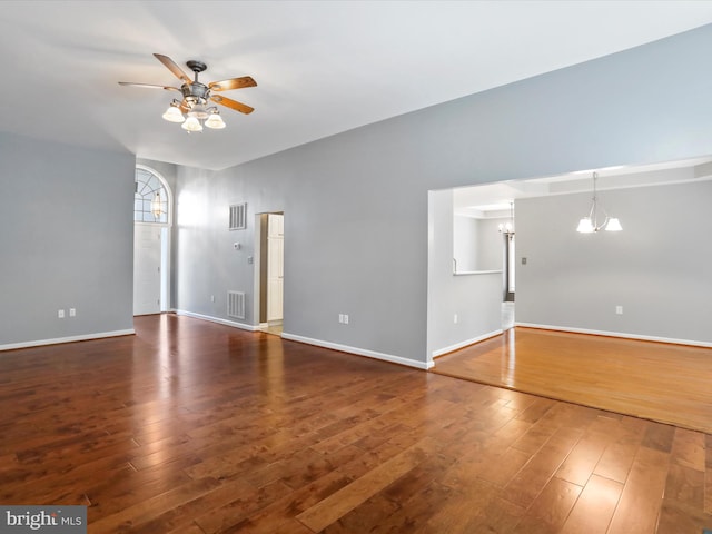 unfurnished living room with dark hardwood / wood-style floors and ceiling fan with notable chandelier