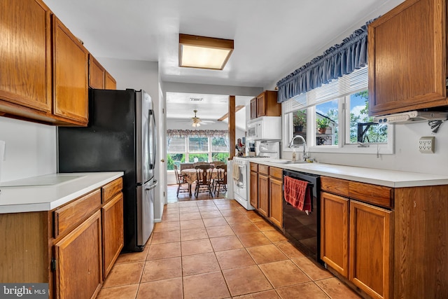 kitchen with light tile patterned flooring, ceiling fan, sink, black dishwasher, and gas range gas stove