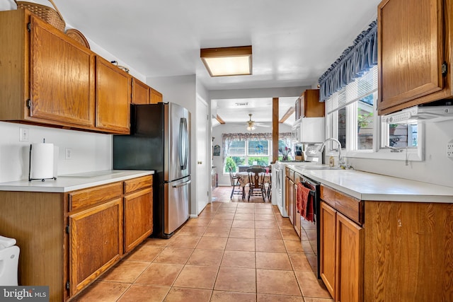 kitchen with ceiling fan, sink, black dishwasher, stainless steel fridge, and light tile patterned floors