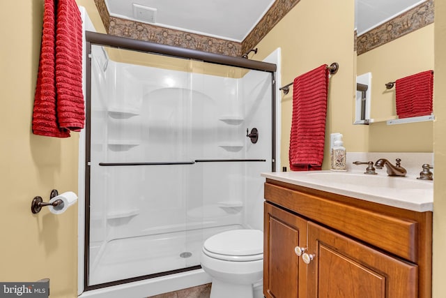 bathroom featuring vanity, toilet, and walk in shower