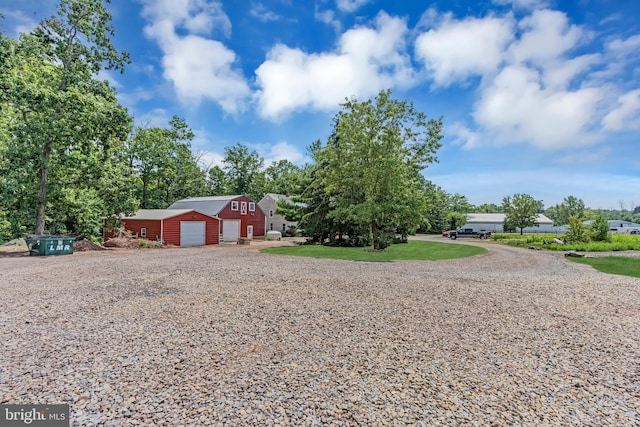 single story home with a garage, an outbuilding, and a front yard