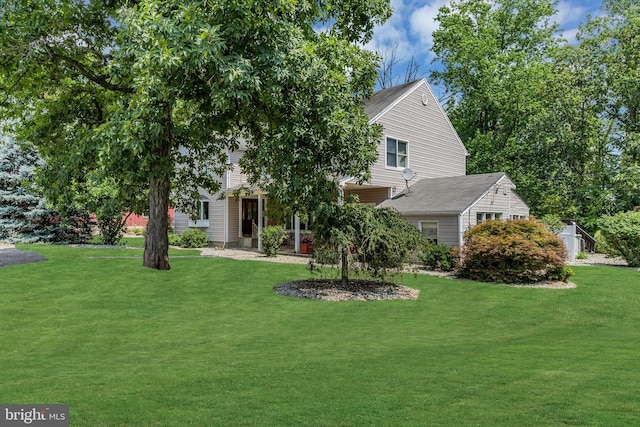 view of property hidden behind natural elements with a front lawn