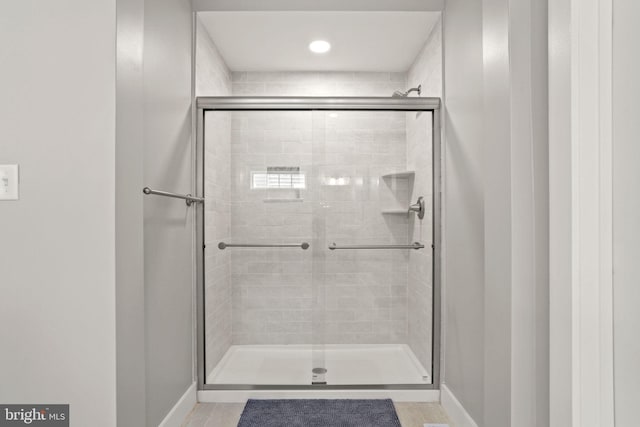 bathroom featuring a shower with shower door