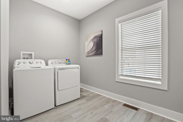 laundry room with separate washer and dryer and light wood-type flooring