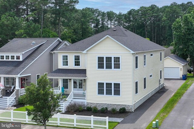 view of front facade with a porch, a garage, and an outbuilding