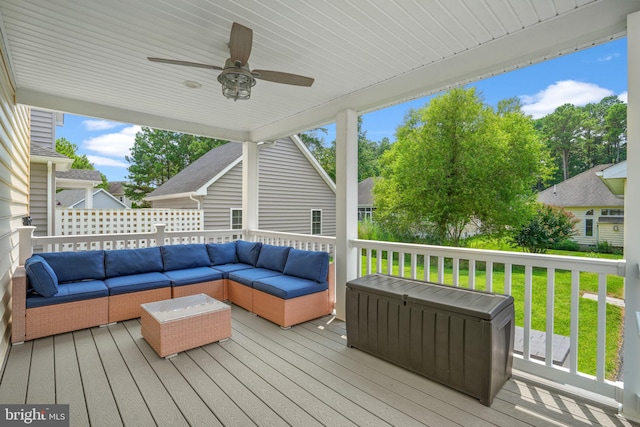 wooden terrace featuring ceiling fan, an outdoor living space, and a yard