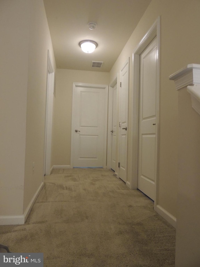 corridor featuring light colored carpet