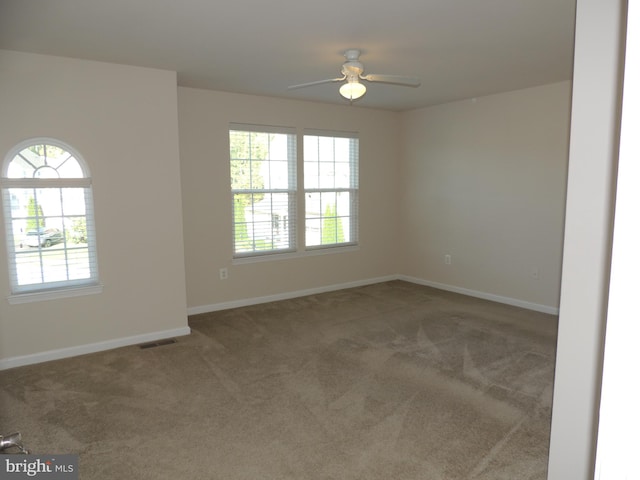 spare room with plenty of natural light, carpet floors, and ceiling fan