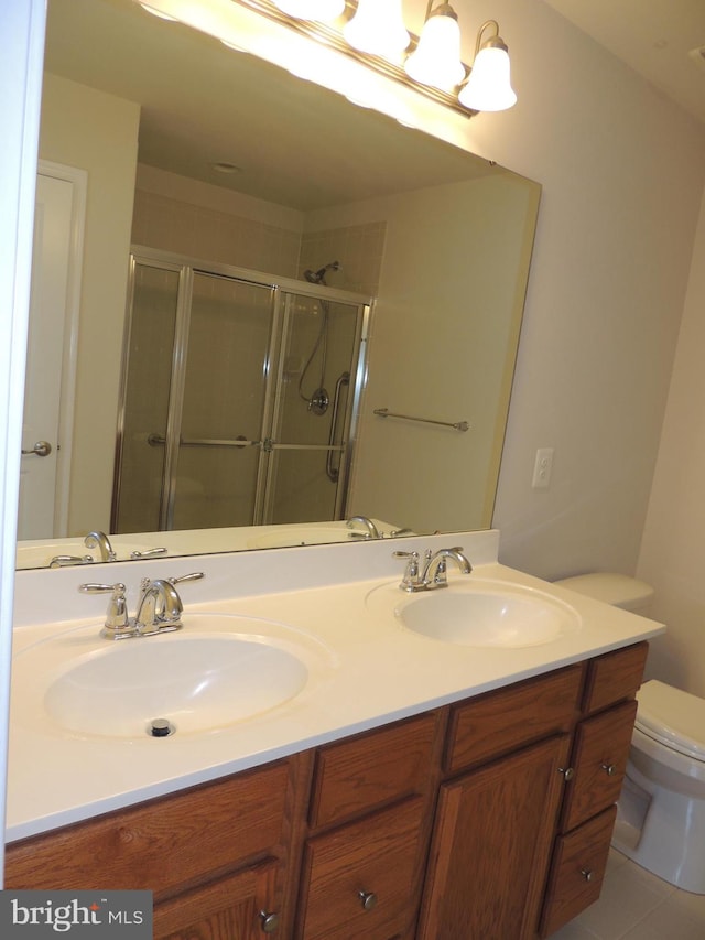 bathroom featuring vanity, toilet, tile patterned floors, and a shower with shower door