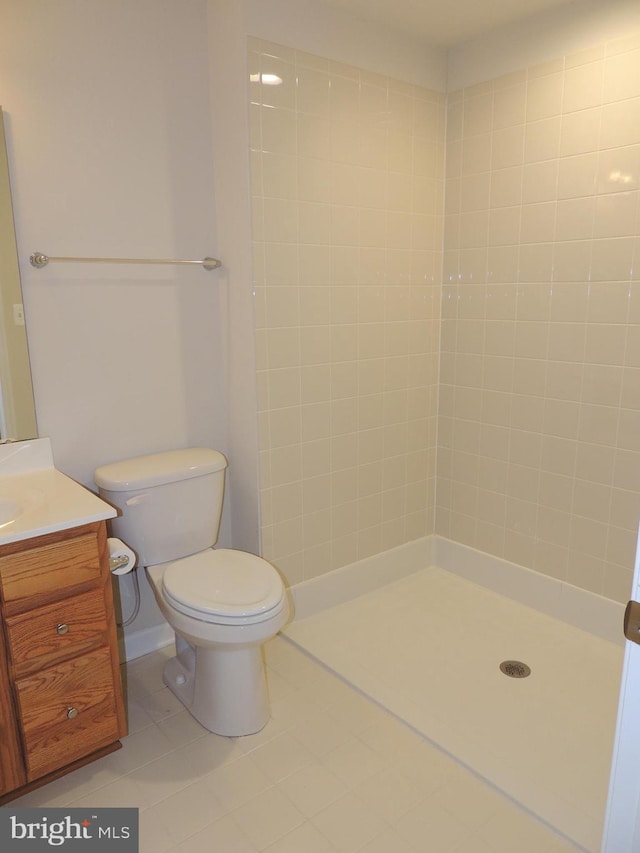 bathroom with vanity, a tile shower, and toilet