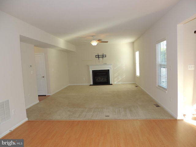 unfurnished living room featuring ceiling fan and light wood-type flooring