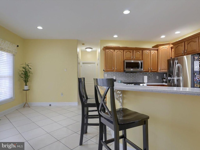 kitchen featuring light tile patterned floors, tasteful backsplash, and stainless steel appliances