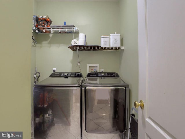 laundry area with washer and clothes dryer and tile patterned flooring