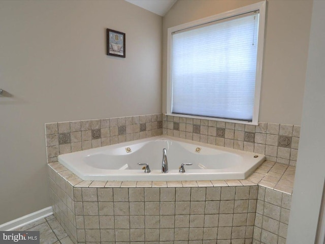 bathroom with tile patterned flooring, lofted ceiling, and a relaxing tiled tub