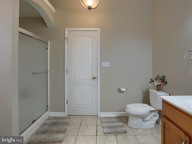 bathroom with a shower with door, tile patterned floors, toilet, and vanity